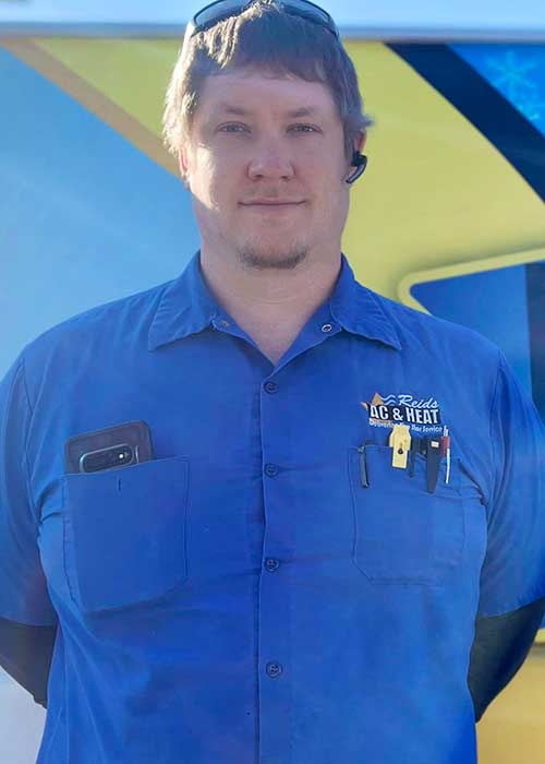 AC repair in Magnolia TX technician Jared standing in from of Reids AC & Heat van.